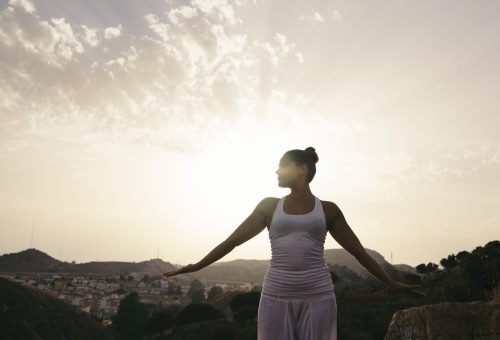woman doing yoga mountainside